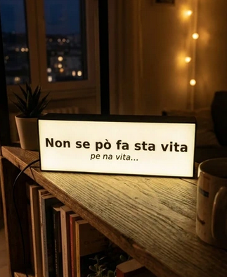 Lightbox con frase "Non se po fa sta vita pe na vita" di Kreo3D, schermo con testo illuminato in ambientazione moderna